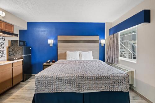 a bedroom with a bed with a blue wall at Blue Wave Inn in Rockport