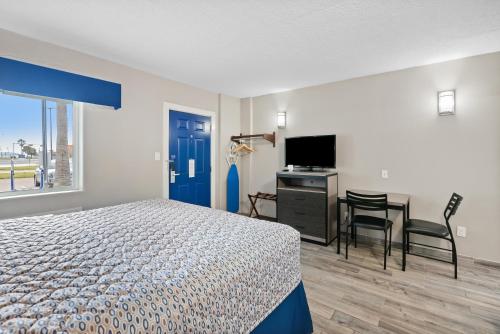 a bedroom with a bed and a desk and a tv at Blue Wave Inn in Rockport