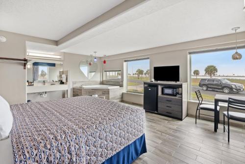 a bedroom with a bed and a kitchen and a television at Blue Wave Inn in Rockport