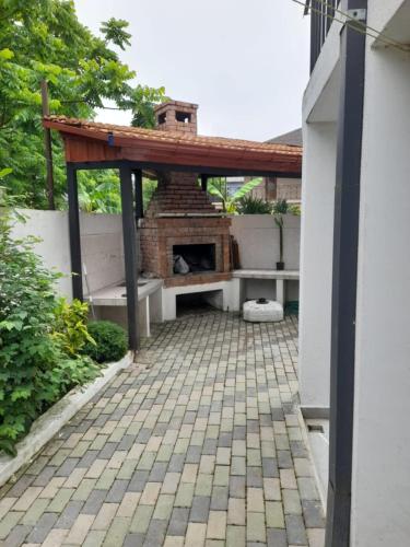 a patio with a brick fireplace in a backyard at LouNik stay hotel and rooms in K'obulet'i
