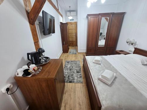 a bedroom with a large bed and a wooden dresser at La Opt Apartments in Oradea