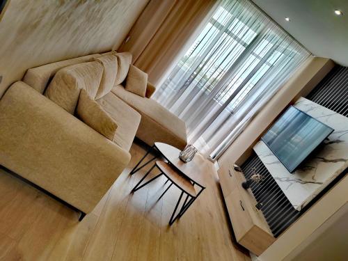 a living room with a couch and a television at MiKi Apartmán Durrës in Durrës