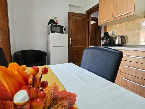 a kitchen with a table with a bowl of fruit on it at Apartment Zarnesti City Centre VMP Free Parking in Zărneşti