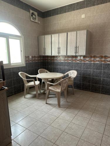 a kitchen with a table and chairs in a room at ديار الكرم للشقق المفروشه in Baljurashi