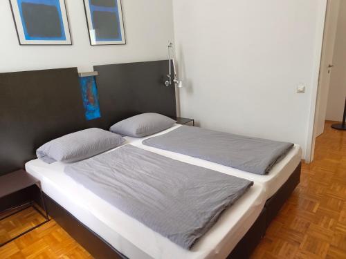 a bed with two pillows on it in a room at WHLIVING - Apartments & Studios in Konstanz in Konstanz