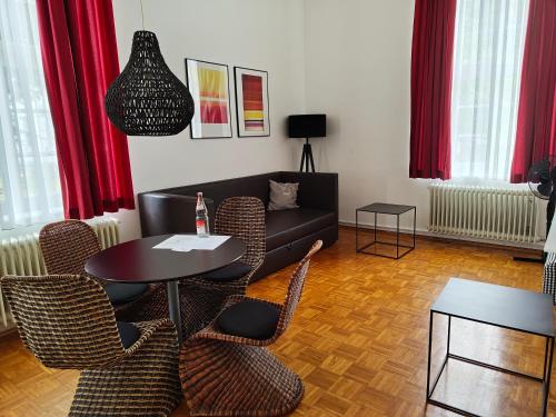 a living room with a couch and a table and chairs at WHLIVING - Apartments & Studios in Konstanz in Konstanz