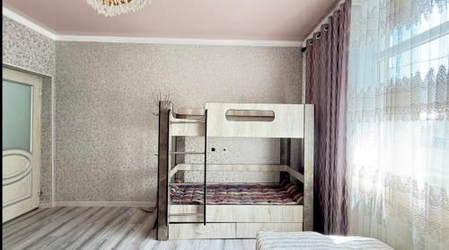 a bedroom with a bunk bed in a room at Дом у Реки in Karakol