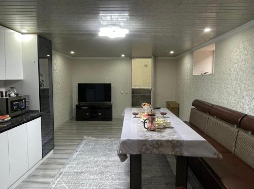 a living room with a table in a kitchen at Дом у Реки in Karakol