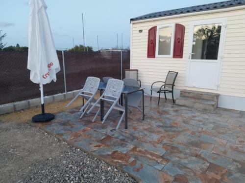 a patio with a table and chairs and an umbrella at Móvilhome in Chiclana de la Frontera