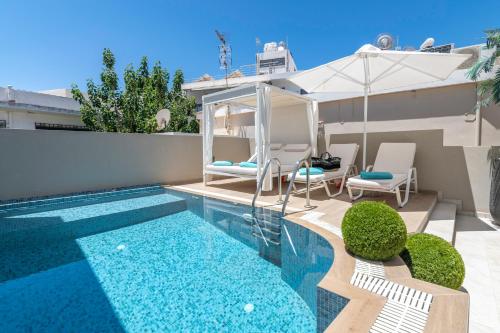 a swimming pool in a backyard with an umbrella at Kallisti Palace - Private Pool with Hydromassage in Kissamos