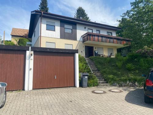 a house with two garage doors and a driveway at Ferienwohnungen Gebhard in Scheidegg