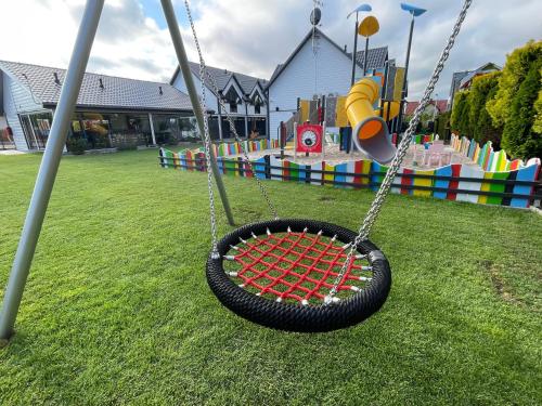 a tire swing in a park with a playground at Amelia Resort in Sianozety