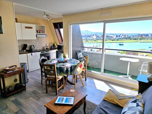 - un salon avec une table et une cuisine avec vue dans l'établissement Duplex mer F2 TV Fibre 5 vélos à disposition, à Cabourg