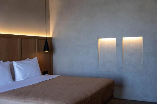 a bedroom with a bed and two lights on the wall at La Torretta Suites & Spa in Pirgos