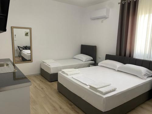 Un dormitorio con dos camas y un espejo. en Arval Rooms, en Vlorë