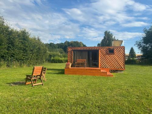 a small cabin in the middle of a field at Obytný kontejner Cabin Stars in Zátor