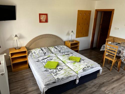 a bedroom with a bed and a table and a television at Penzion U pily in Paseky nad Jizerou
