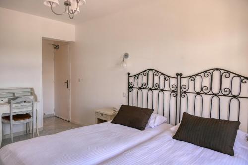 a bedroom with a large white bed and a desk at Logis Hôtel Le Manoir & Lounge in Apt