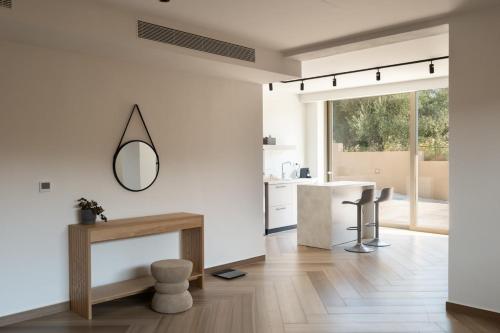 a white kitchen with a table and a mirror at Villa Neratzia-Luxury Escape in Nerianá
