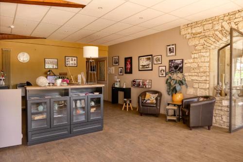 a waiting room with a counter and a stone wall at Logis Hôtel Le Manoir & Lounge in Apt
