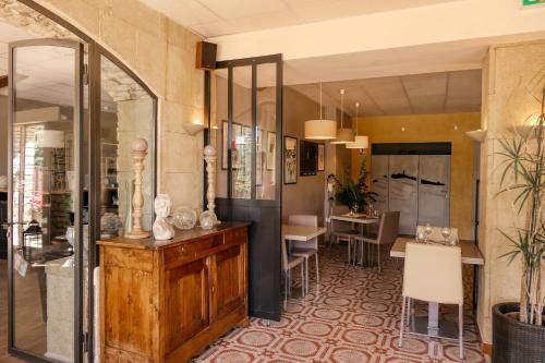 a lobby of a hotel with a dining area and a table at Logis Hôtel Le Manoir & Lounge in Apt