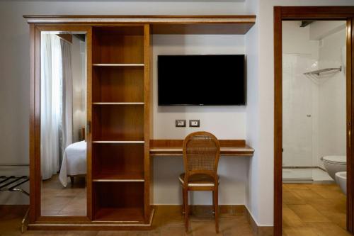a room with a tv and a chair in a room at Four Points Flex by Sheraton Naples Marigliano in Marigliano
