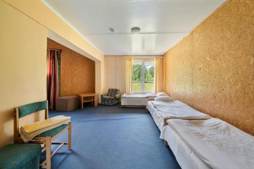 a room with three beds and a window at Poilsio kompleksas Tolieja Vieta renginiams bei poilsiui ant ežero kranto in Kulionys