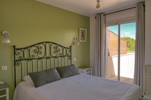 a bedroom with a bed and a sliding glass door at Logis Hôtel Le Manoir & Lounge in Apt