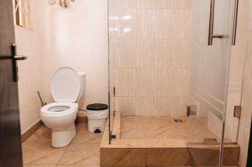 a bathroom with a toilet and a glass shower at Deluxe 1 BedRoom Adjiriganor RealShala in Ashalebotwe