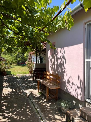 a wooden bench sitting on the side of a building at Maryland Vendégház in Bogács