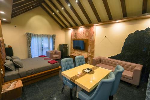 a bedroom with a bed and a table and chairs at Aamara in Bengaluru