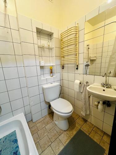 a bathroom with a toilet and a sink and a tub at Manto Apartment in Klaipėda