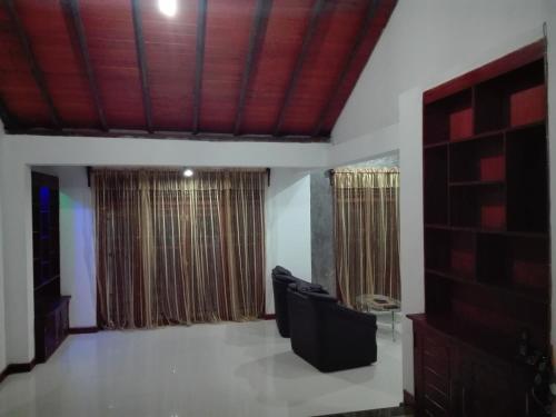 a living room with a couch and some windows at Sinhalaya 