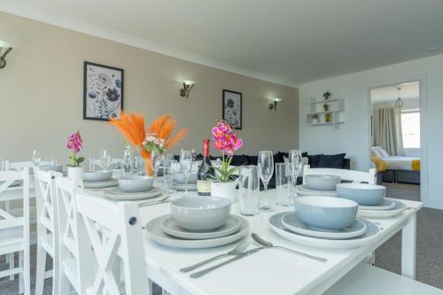 a white table with plates and bowls on it at Open Mind Property - Four Bedroom House in Portsmouth