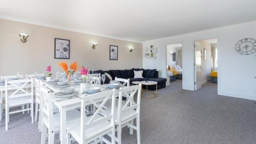 a white dining room with a white table and chairs at Open Mind Property - Four Bedroom House in Portsmouth