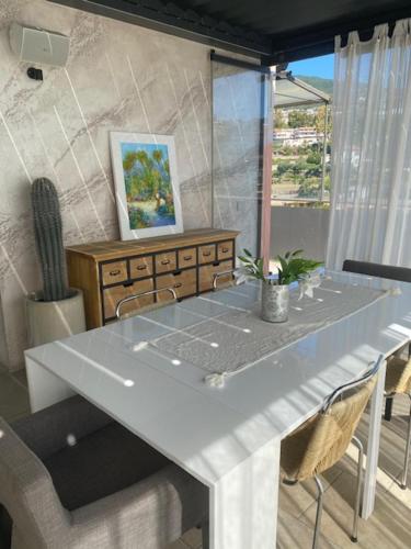 a white table with chairs in a room at PhilHouse, Jacuzzi Seaview & Bbq in Sanremo