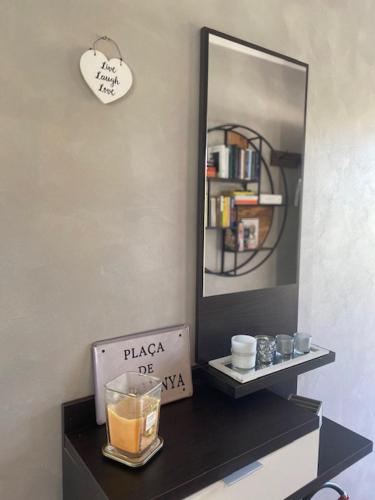a table with a mirror and a clock on a wall at PhilHouse, Jacuzzi Seaview & Bbq in Sanremo
