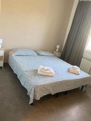 a bedroom with a bed with two towels on it at PhilHouse, Jacuzzi Seaview & Bbq in Sanremo