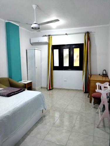 a bedroom with a bed and a table and windows at room 3 a room in Hostel of 4 rooms in Hurghada