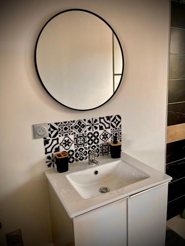 a bathroom with a sink and a mirror on the wall at KALME Spa&Sauna - Maison avec Spa et Sauna privatifs in Chécy