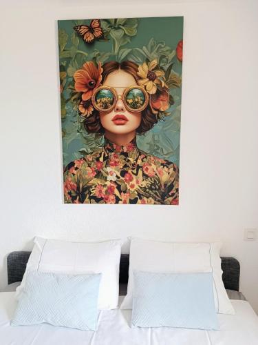 une peinture d'une femme avec des lunettes de soleil sur la tête dans l'établissement Au levant de Marie, à Gaillac
