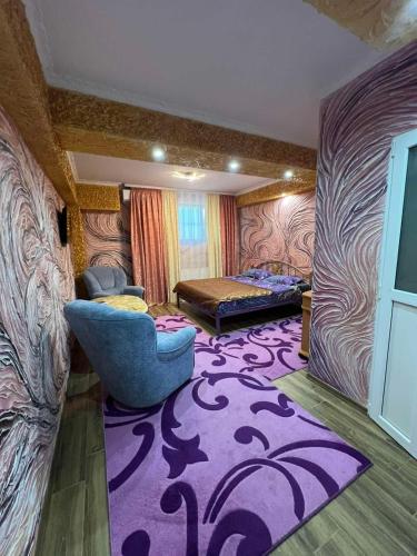 a room with a purple rug and a bed and a chair at Golden Rose in Chişinău