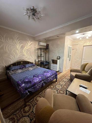 a bedroom with a bed and a couch and chairs at Golden Rose in Chişinău