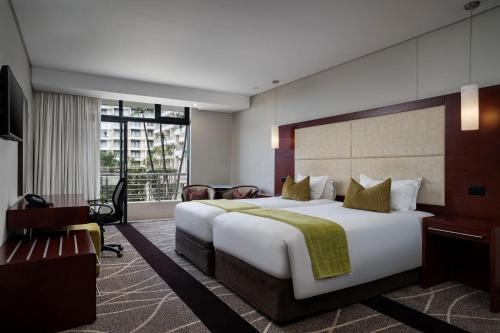 a hotel room with a large bed and a desk at Premier Hotel East London ICC in East London