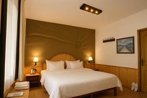 a bedroom with a large bed with white sheets at Beholden Stay and Cafe - A Luxury Boutique Hotel in Manali in Manāli