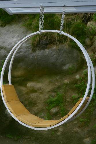 an empty swing in a playground with a swing at Beholden Stay and Cafe - A Luxury Boutique Hotel in Manali in Manāli