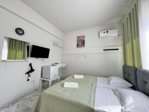 Una habitación blanca con una cama y un televisor. en Smart Comfort RoomN3 with Private Bathroom in best Location Beach 250m, en Limassol