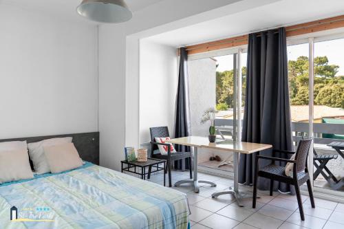 une chambre avec un lit, une table et des chaises dans l'établissement Camping Oléron St-Tro'Park, à Saint-Trojan-les-Bains