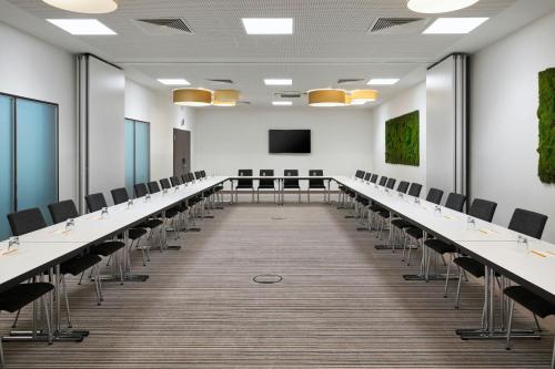 an empty conference room with rows of tables and chairs at Four Points Flex by Sheraton Essen in Essen