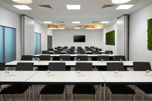 a conference room with tables and chairs and a podium at Four Points Flex by Sheraton Essen in Essen